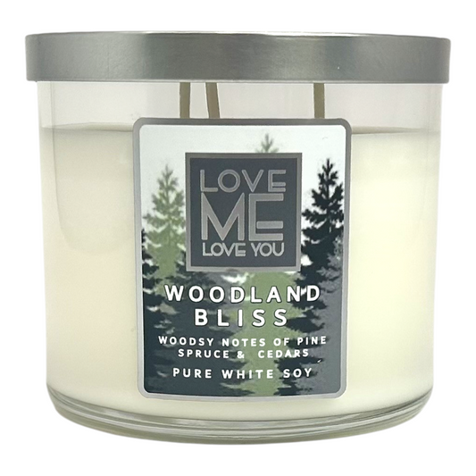 Woodland Bliss candle in clear jar with gray lid; pine tree label and white soy text